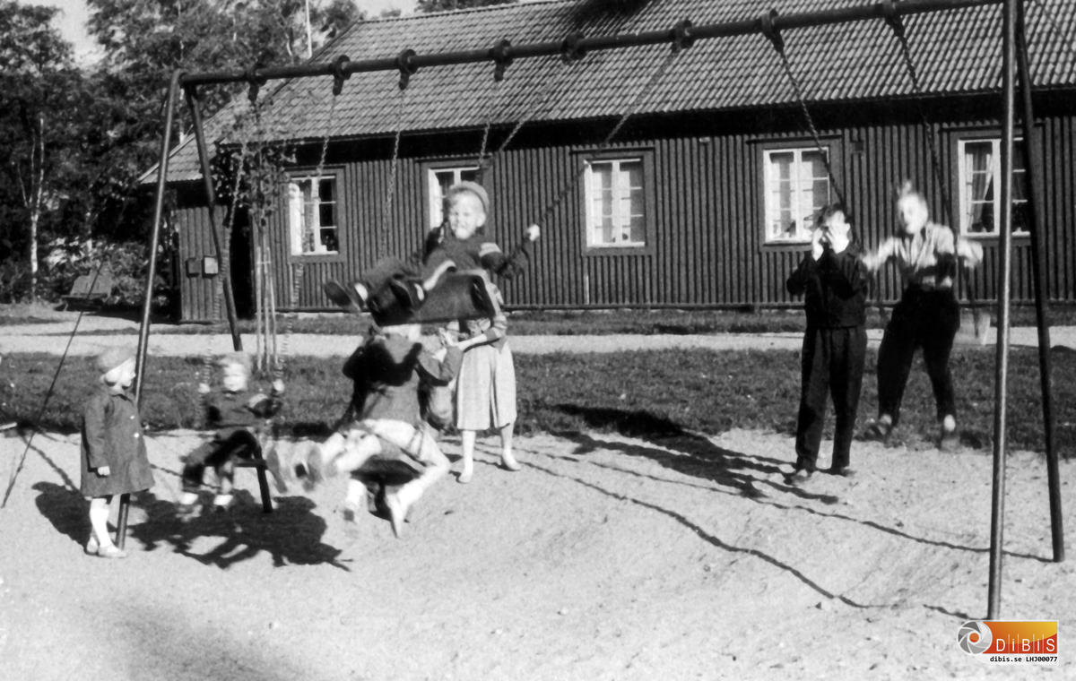 Bilden föreställer lekplatsen på Bruket i Ala.
Flickan i gungan till vänster är Monika Johansson i gungan som är närmast kameran sitter Jörgen Johansson i den högra gungan sitter Lars Nerlund och den som övervakar det hela är Tage Johansson.