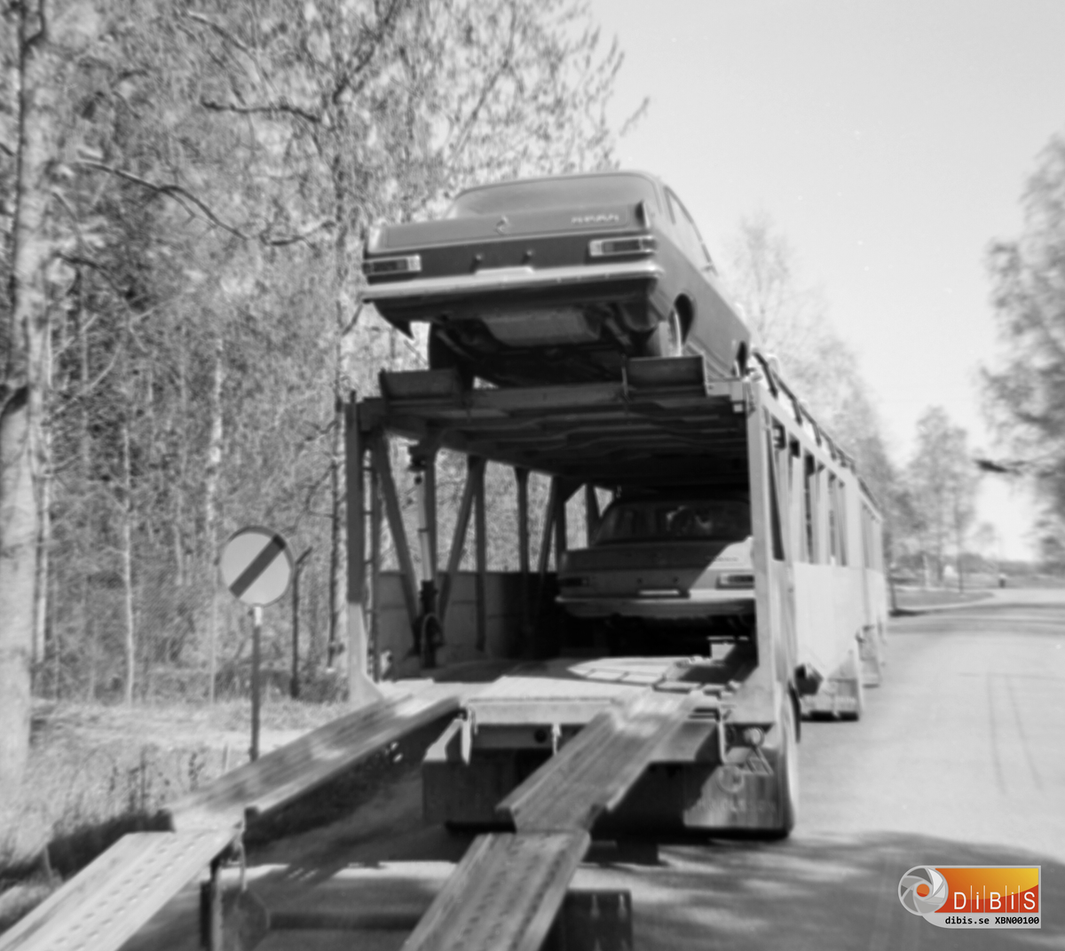 Biltransport på väg norrut på dåvarande E4 på södra sidan av gamla Ljusne bron.
Man fick lasta av de nya personbilarna och köra över dem en och en för att sedan lasta på dem vid Lugnet för fortsatt färd norrut.
Det var vänstertrafik som gällde då.