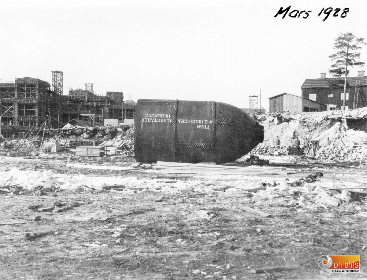 Motiv taget från industrispåren 8  mars 1928.
Maskindelar börjar nu komma till Marma, detta är en halv kokare som lossats från en järnvägsvagn. Hedemora Verkstäder var en stor leverantör på den här sortens material.