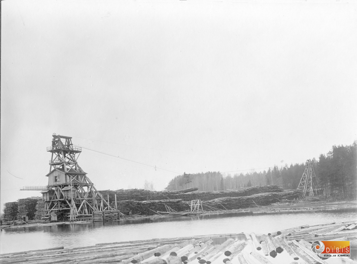 Sågverkets första timmerkran byggdes i trä och uppfördes 1917. Krantornen flyttades på räls vart efter travarna med timmer blev färdiga. Det bortre tornet var ett pendeltorn och hade en motvikt för den tyngd som uppstod när "katten" löpte på linan med sin timmerlast. Våren 1934 bröts det bortre tornet av och rasade ihop varefter man byggde nya torn i järnkonstruktion. De stod kvar till den 25/1 1963 då det hela skars ned och såldes som skrot.