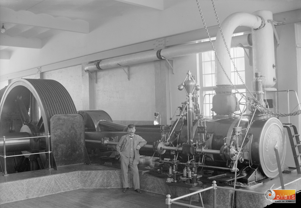 Sågverkets ångmaskin som installerades 1915 och var i drft fram till 1938 då man gick över till el-drift på alla maskiner. Framför ångmaskinen står maskinmästare Johan Israelsson som gick i pension med maskinen.