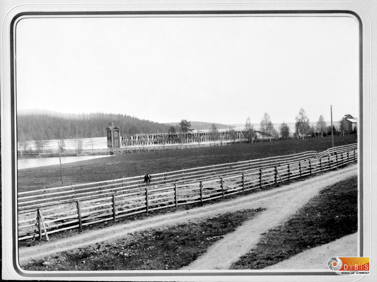 Fotoarbete av John B av annan fotografs bild.
Bilden visar den första timmerlagrins-anordningen vid sågverket i Marma.
Den var i bruk fram rill 1917.
Den här bilden är tagen vid högvattenstånd.