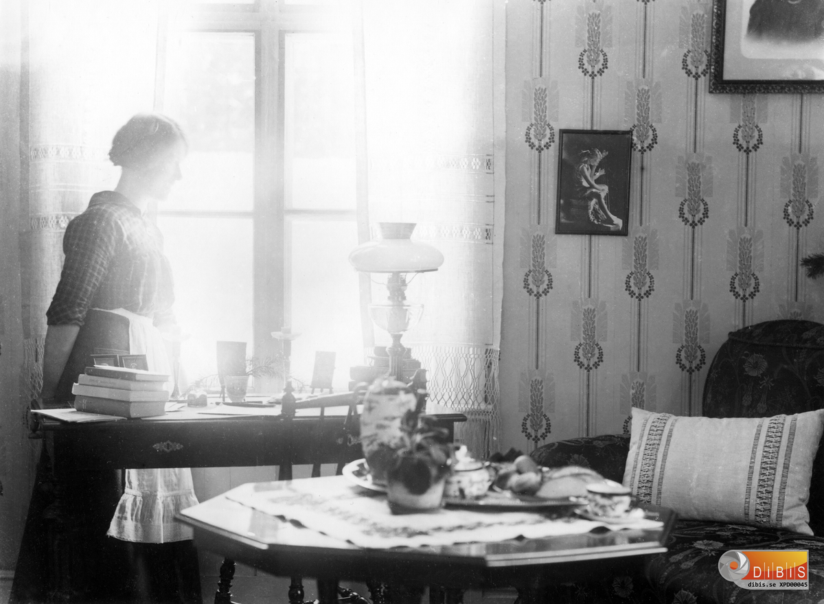 Interiörbild från fotografens hem.
Dottern Jenny Lind vid fönstret.