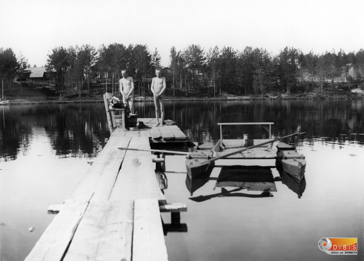 Herman Lind och Lars Larsson badar. Juni 1909.
Herman Lind och Högkvists Lars Larsson, båda födda 1895 på Smelinds brygga, med Brolins gård i bakgrunden.
(Se även XPD 00106, XPD 00107 och XPD 00108).