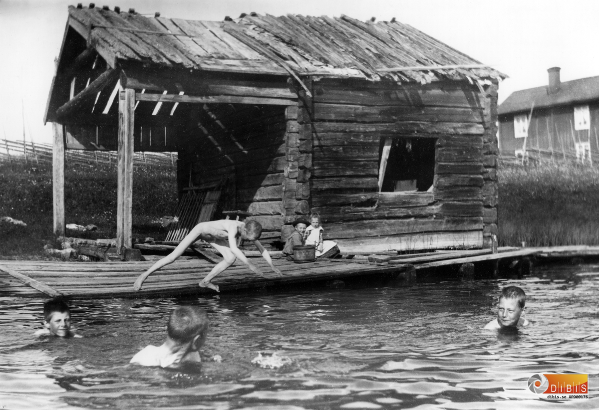Badbild från Perjons linbod vid Föltjärn med Smelinds i bakgrunden. På bron sitter Herman Lind och Maria Lind. Övriga är okända.
Bilden är tagen omkring 1898-99.