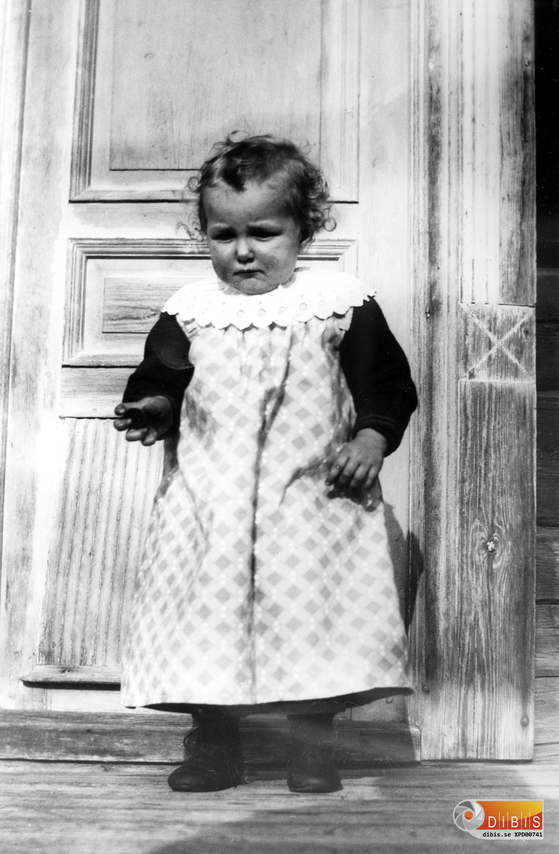Liten flicka framför ytterdörren, Glösbo ? 1890-talet.