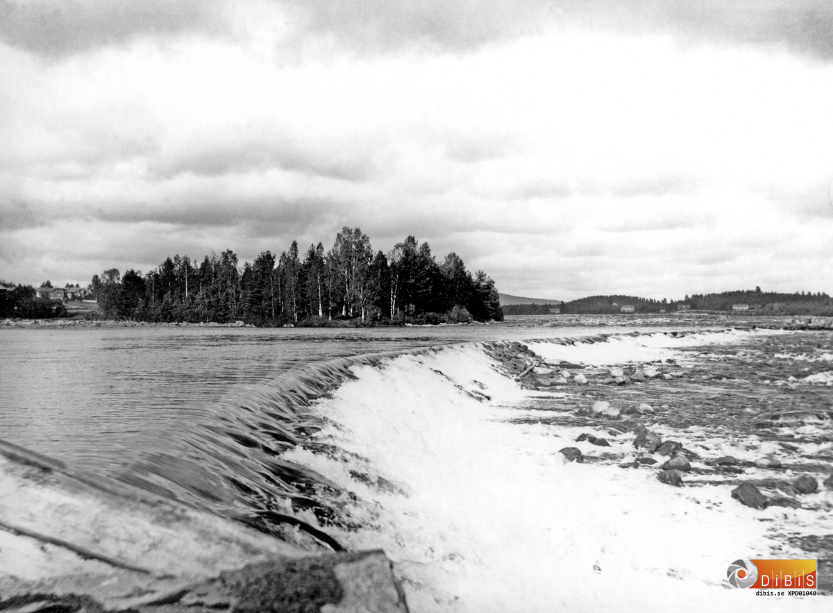 Bollnäs, Ljusnan vid Broddlägret. Bilden visar fångdammen uppströms Broddlägrets kvarn och kraftverk. Skogen närmast bakom i bild ligger på Langens ö.
