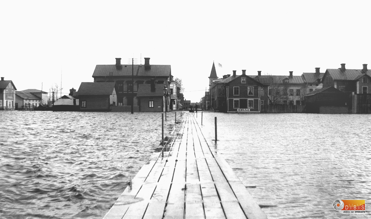 Bollnäs översvämningen 1909. Vy från järnvägshotellet, med ”spången” och Stationsgatan. Det stora huset till vänster är Helins Bokhandel.