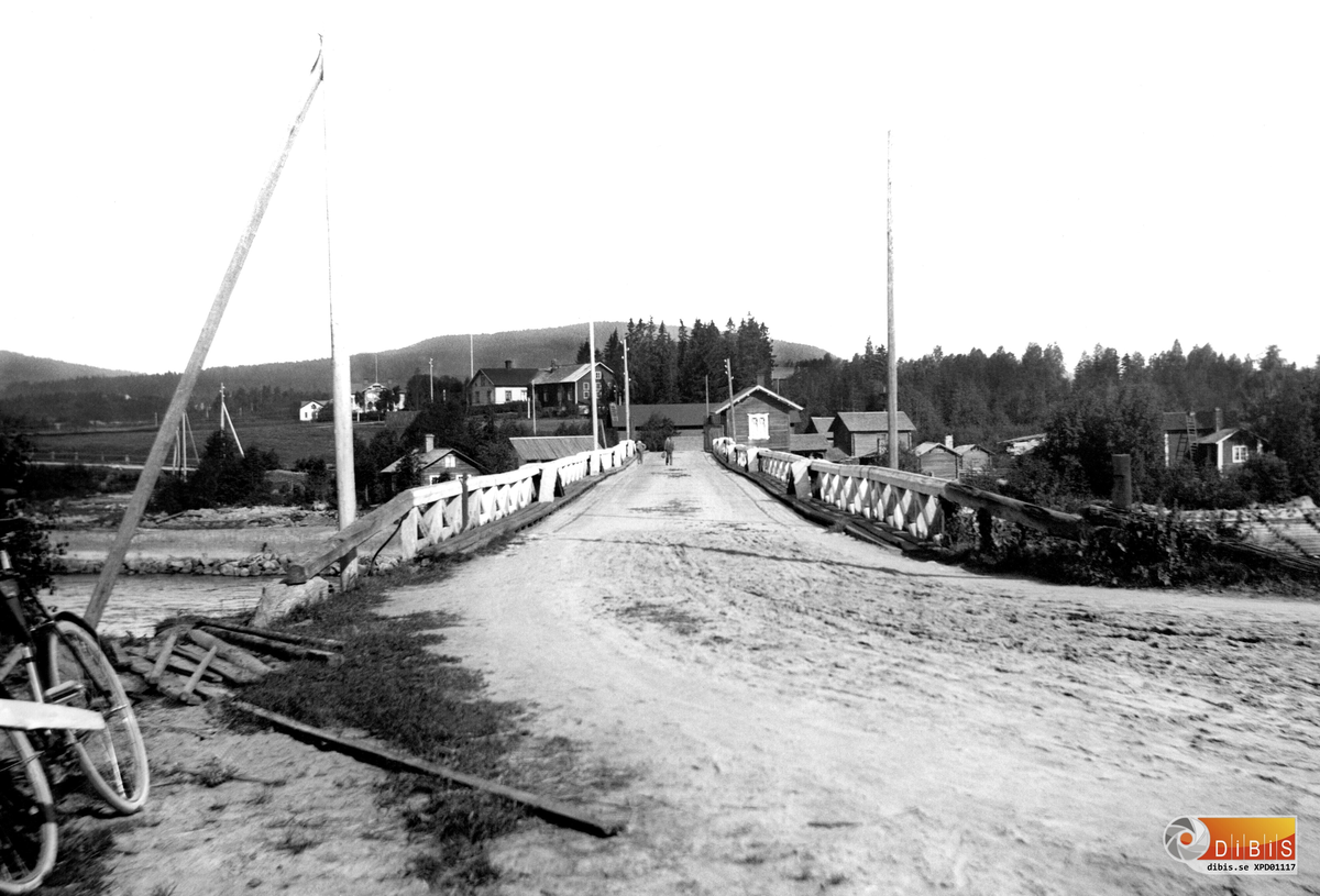 Arbrå i slutet av 1890-talet. Gamla strömbron från öster mot väster. Ny bro byggdes 1914. Till höger om bron ses brostugan och till vänster, nere vid vattnet Holmkvists.
