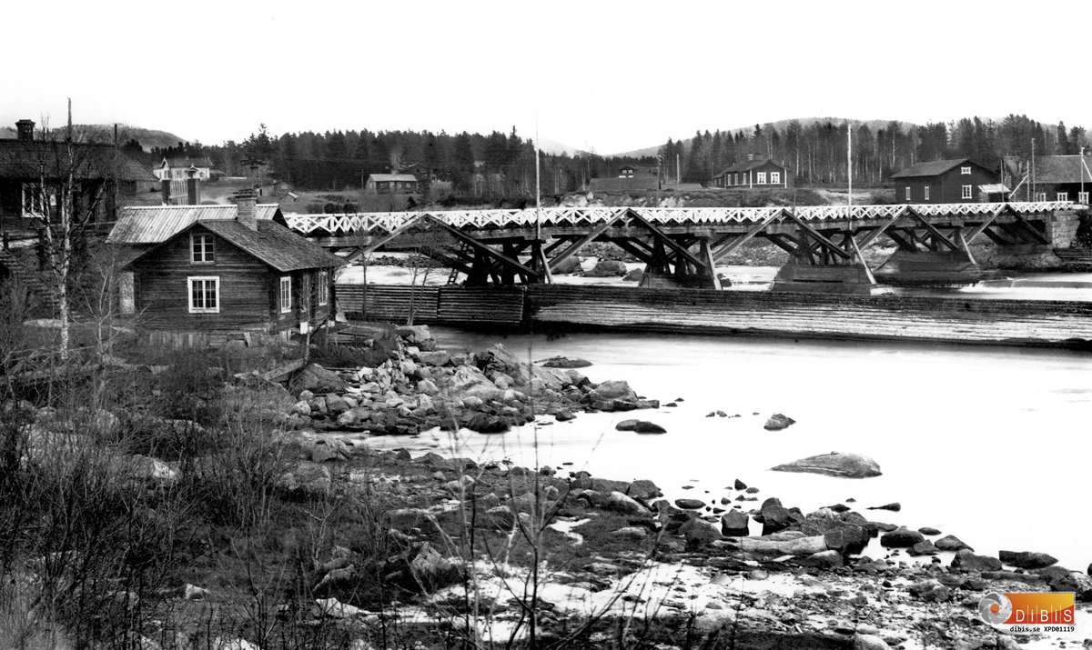 Arbrå i slutet av 1890-talet. Gamla Strömsbron. Vy på östra sidan, från vänster ser man fotograf Petterssons, okänt, Perses, arbetarbostad, spinnerifabriken och kvarnstugan.