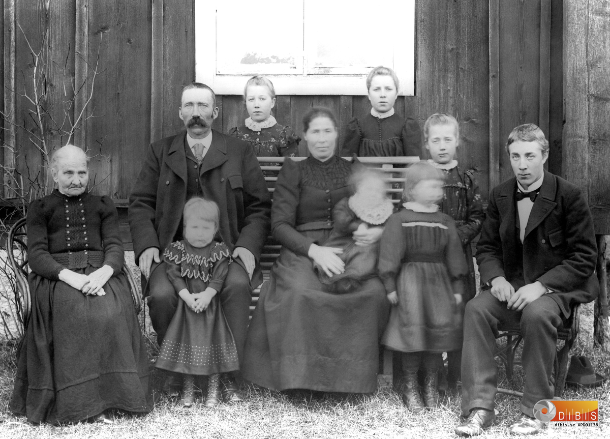 SKOGVAKTARE JOHAN EKSTRÖMS, byggde Brorssons bakom Jonnes i Arbrå år 1901. Bodde tidigare på Skräddartorp. Han kom från Växsjö. Hans mor är med på fotot t.v. Frun heter Anna och kom från Stavsätra Järvsö. Barnen (utan anknytning till ordn. på fotot) Anna (g.m snickar G.A. Nilsson), Ida och Tilda (åkte till America), Signe (gift med Kuno Norén), Emma (g.m Skräddare Sjödin, tidigare piga hos Arvik), Elin och Erik, Bricken (ett av barnen fött 1902 och ej med på fotot enl. Jonas Östling).    (se även nr 1138-1141)