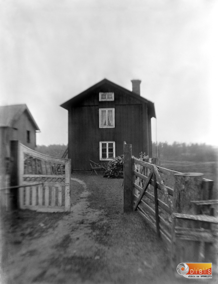 Smelinds gården fotograferad från vägen med grinden i förgrunden. Troligen omkring 1897-1900.