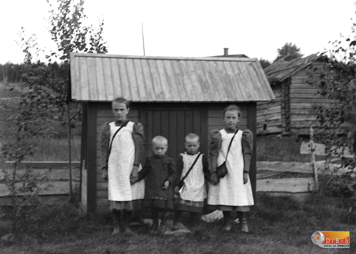 Smelinds fyra barn framför lekstugan. Flickorna har ljusa förkläden och väskor.