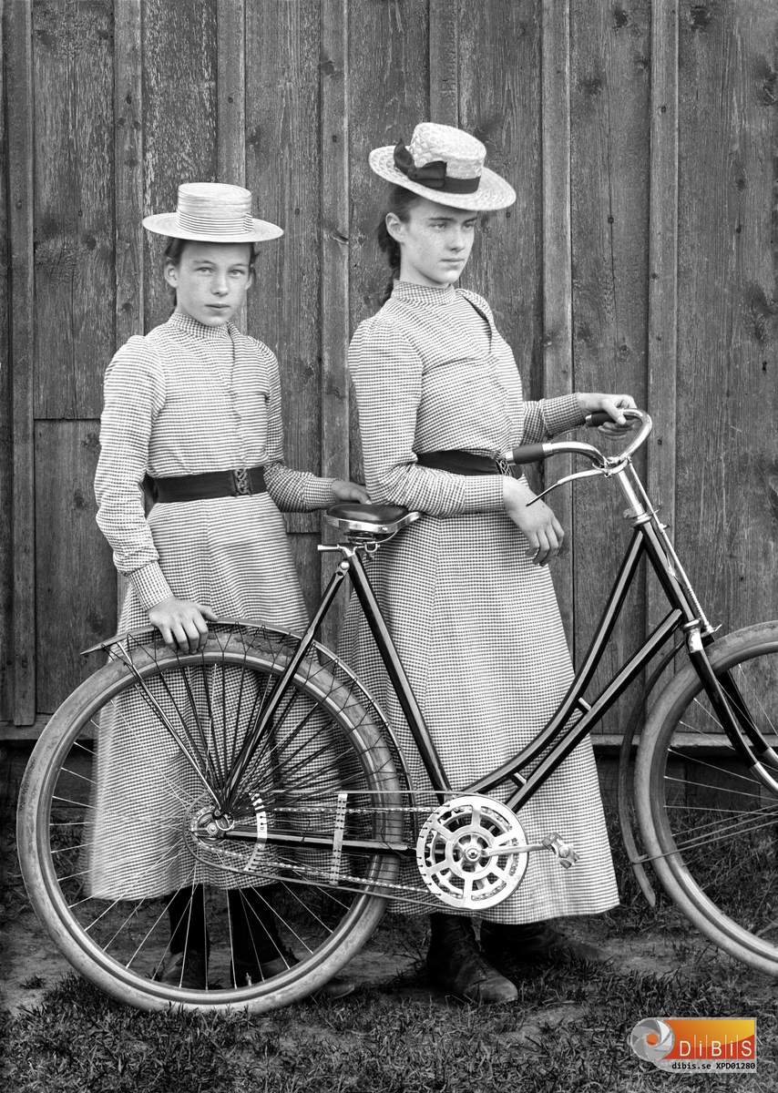 Smelinds Märta Lind och Jenny Lind med en cykel vid byggningsväggen.