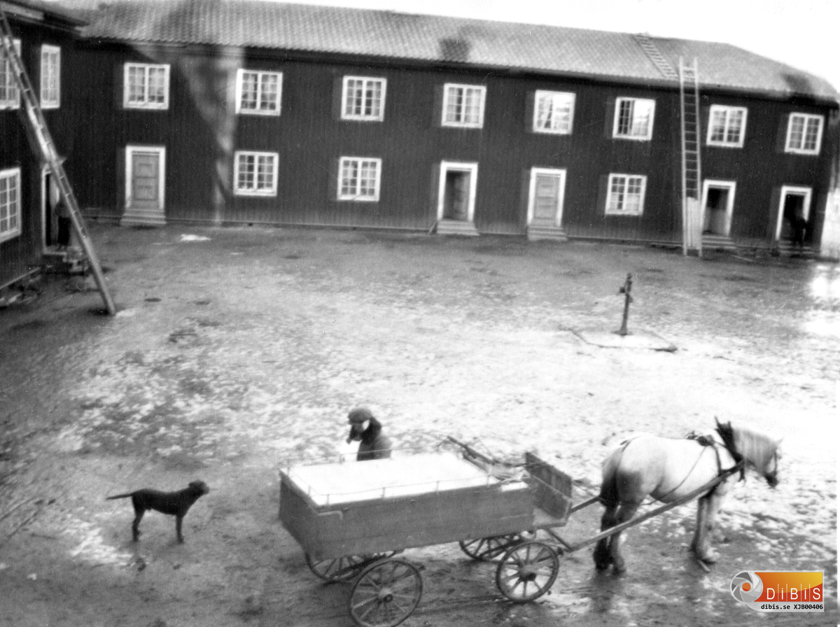 Byggnaden är den som stod mittemot Villan på Stenbacka. Aktiviteten är att slaktaren har kommit till området för att få sälja lite kött o korv.