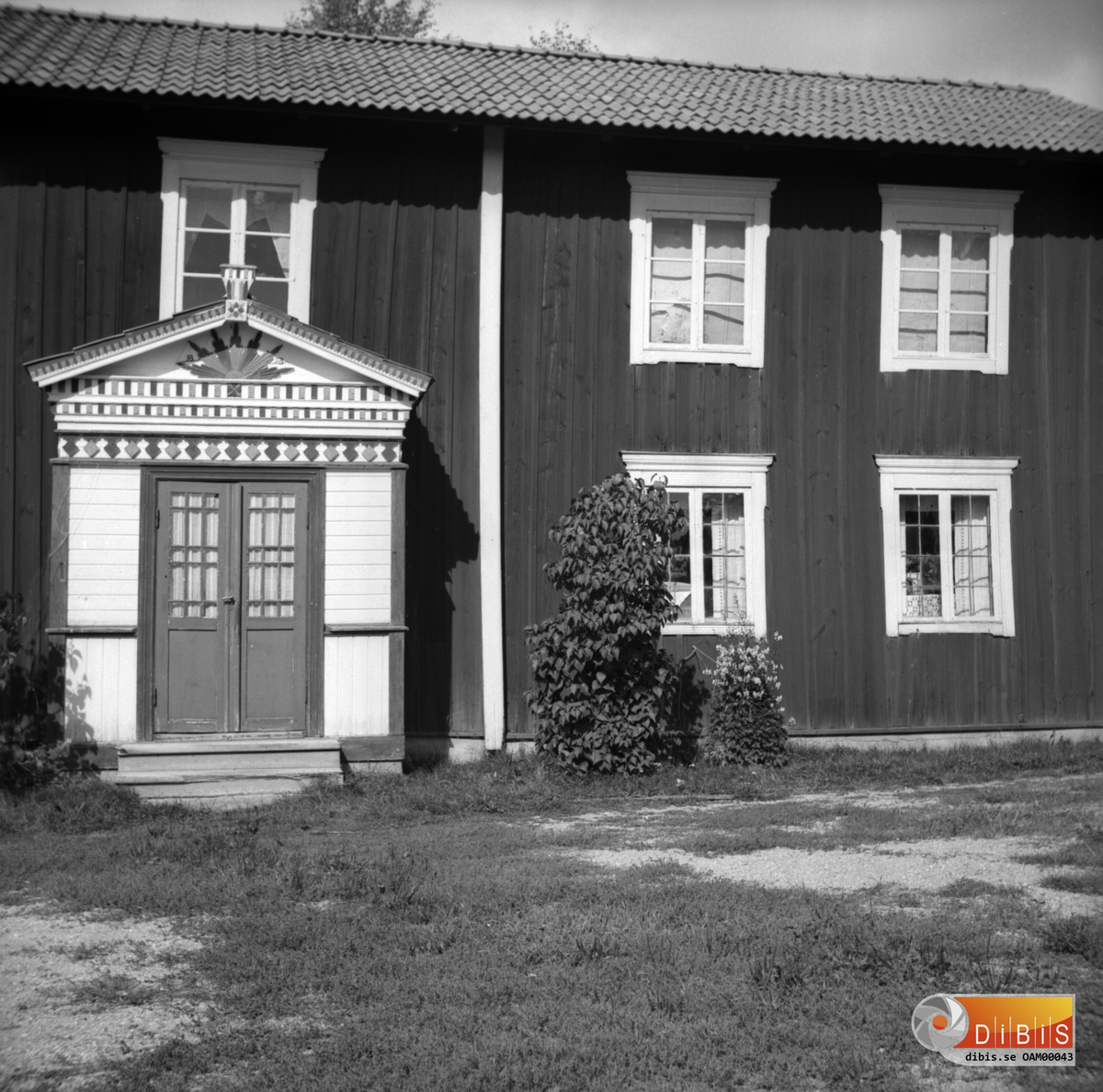 En hälsingegård med utsmyckad brokvist.