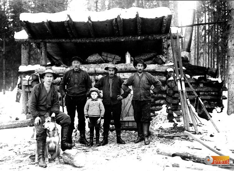 Skogsarbetarebostad koja med fyra män en pojke och en hund.
Fr.v. Nyasa-Per, Grota-Arvid Olsson, Martin son till  A.O.,
Lustes-Jonas, Lustes-Erik.