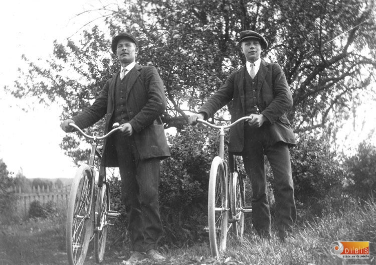 Två okända män med cyklar.