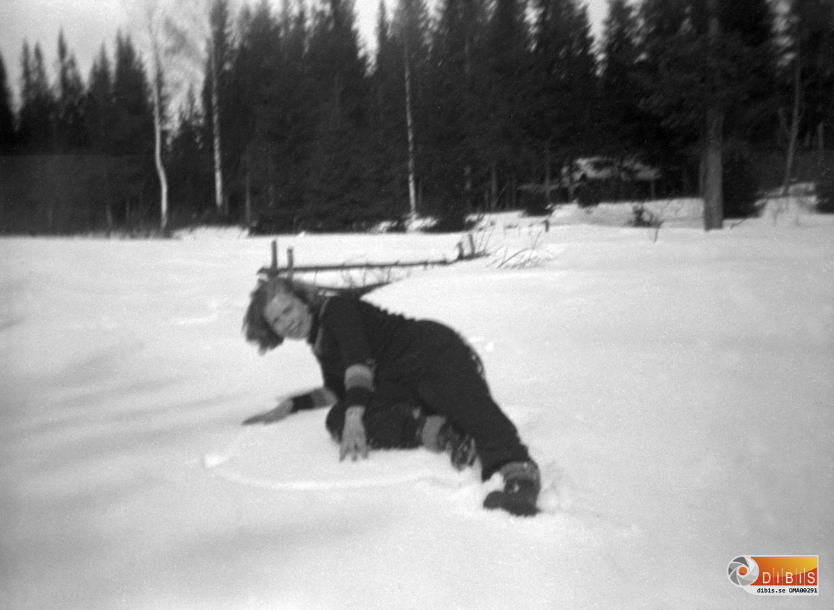 En flicka som ligger i snön.