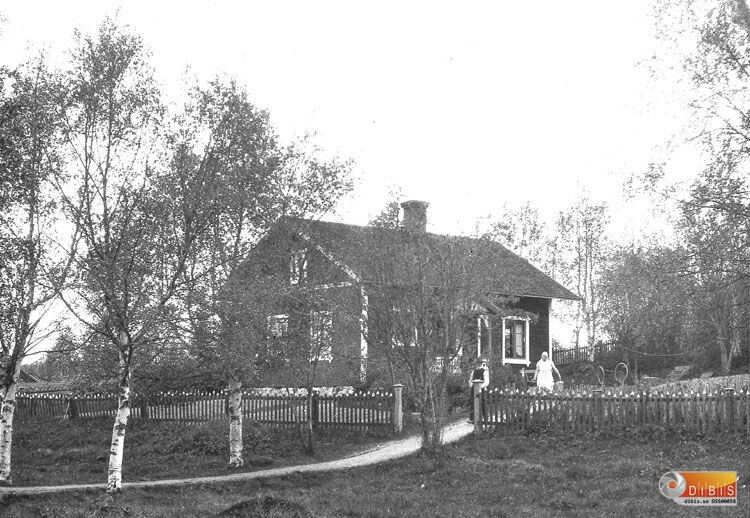 Okänt bostadshus.
En okänd kvinna som bär två hinkar ,
och en man på vägen.