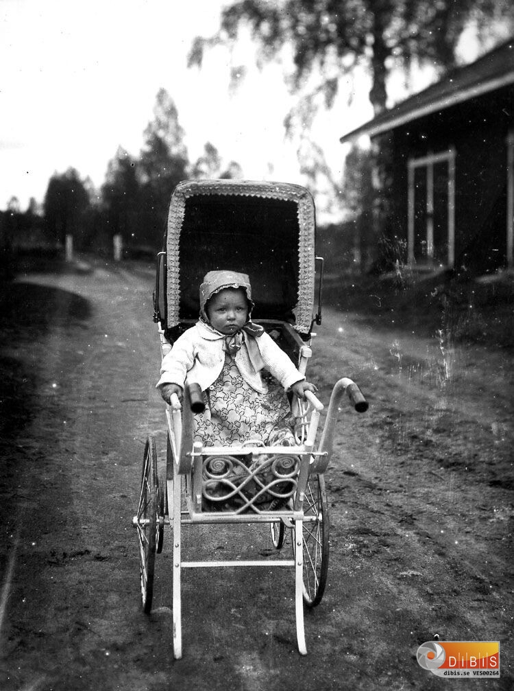 En flicka i en vacker barnvagn