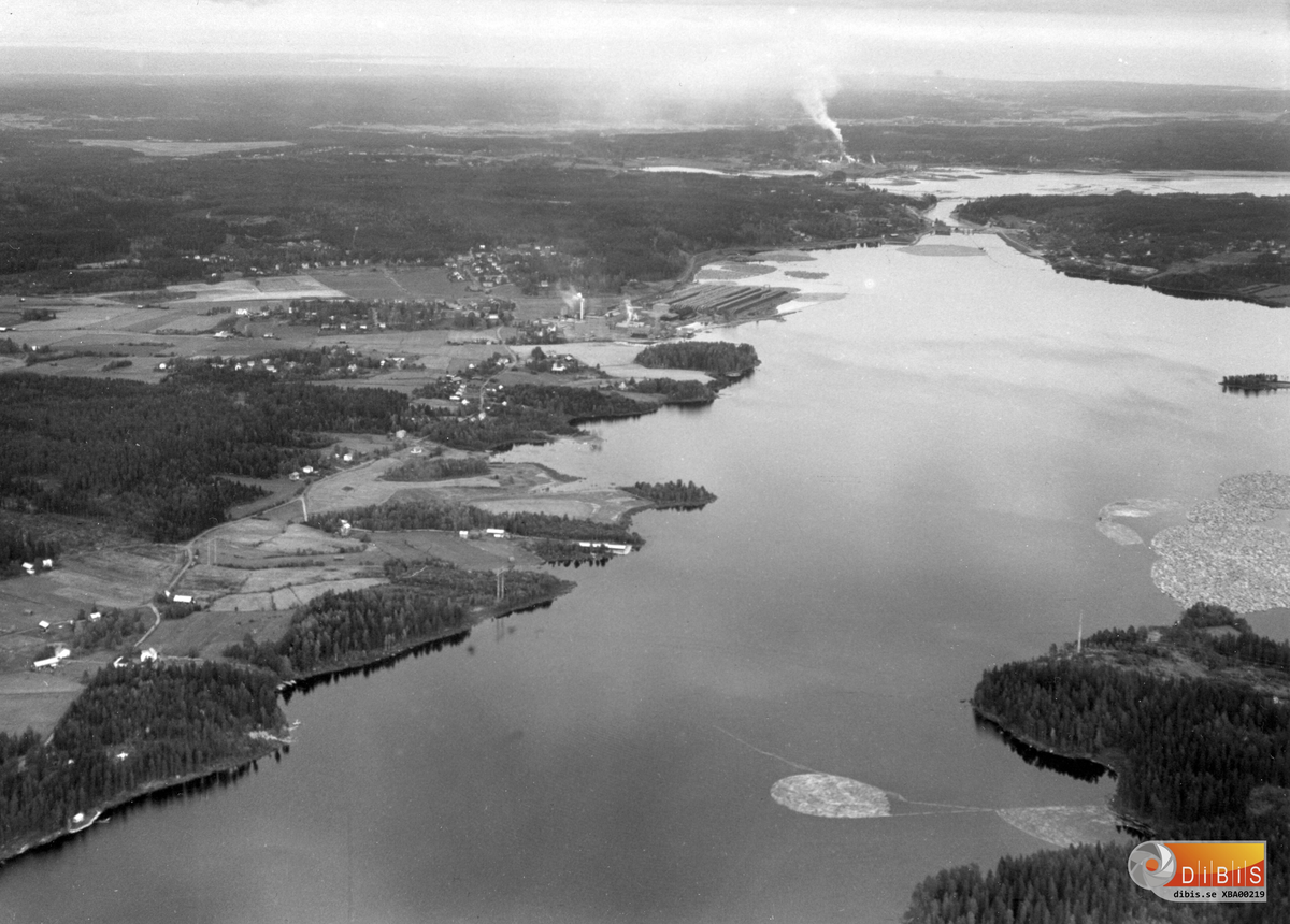 Bilden visar Smalsjön, en del av Bergviken.
Till vänster ett landskap med början i Fallen, Vannsätter, och avslut mot en horisont som visar fabriken i Marmaverken och delar av landskapet i Söderala.
Fabriken i Vannsätter är i drift med bland annat de staplar av virke som var förråd och intag av råvara fram till den flishantering som användes när flottningen upphört och allt virke kom med lastbil.