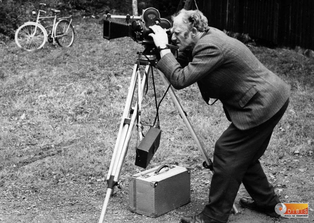 Helmer Björklund har tagit ett både roligt och karaktäristiskt arbetsporträtt av Johan Wiklund i hans roll som filmfotograf.
Tyvärr gick många av filmerna förlorade när bostaden på Enmyra eldhärjades. En del av materialet gick att restaurera och andra filmer finns kvar hos beställare. Johan gjorde bland annat filmer på uppdrag av Bergvik&Ala AB.

Johans egna filmprojekt
År 1954 började Johan göra egna filmer med 16 mm format. Först med en enklare kamera och längre fram med en Arriflex identisk med den tidens proffskameror för reportage i fält.
Flera av filmerna visades i TV. Exempelvis:
- En sommardag med Nikko
– Poppi
– Grävlingen och hans grannar
– Min vita vinterpäls
– Våra draghundar
– Micklamor med sina små
– Vår vita kråka
– Grävlingen och ekorrarna
– En film om igelkottar
Detta var titlar Johan satte på sina filmer.
I filmen om Nikko deltog syskonbarnet Åsa Wiklund.
Johan berättar också om uppdraget för Bergvik&Ala.
Ett arbete som tog fyra år och gav en film som
i dag är ett värdefullt stycke historia.
Under 1950- och 1960-talet anade nog ingen att detta anrika bolag inom några år skulle upphöra.