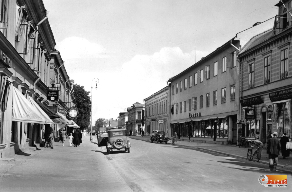 Köpmangatan i Söderhamn med Konsum och Konsumbaren till höger. Bilparken anger bildens ålder. Inte något av denna bebyggelse finns kvar. Allt ersattes successivt med ny bebyggelse. Flera av de gamla fastigheterna hade grundläggning av sådant slag att de var hotade. Rivning var enda utvägen.