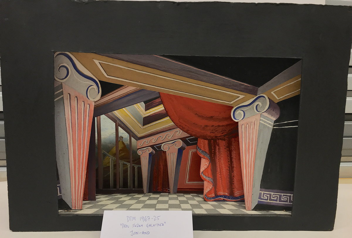 Ett gemak med stiliserade joniska kolonner som uppbär bjälklag, röda draperier med blå bård. Perspektiven oregelbundna. Till vänster genom ett gallerverk en utsikt mot ett berglandskap med ett litet tempel. Golvet är schackrutemönstrat i grått och vitt. 
