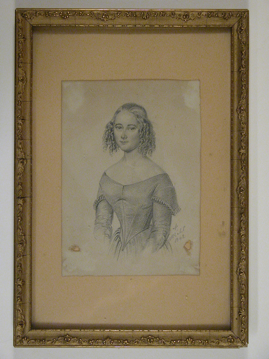 Blyerstteckning föreställande en ung kvinna. Inramad i guldfärgad träram.
