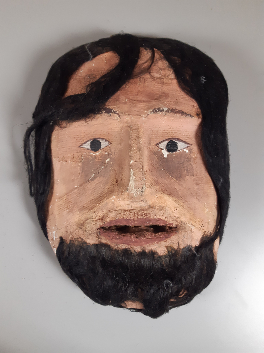 Mask föreställande man med mörkt hår och skägg,
