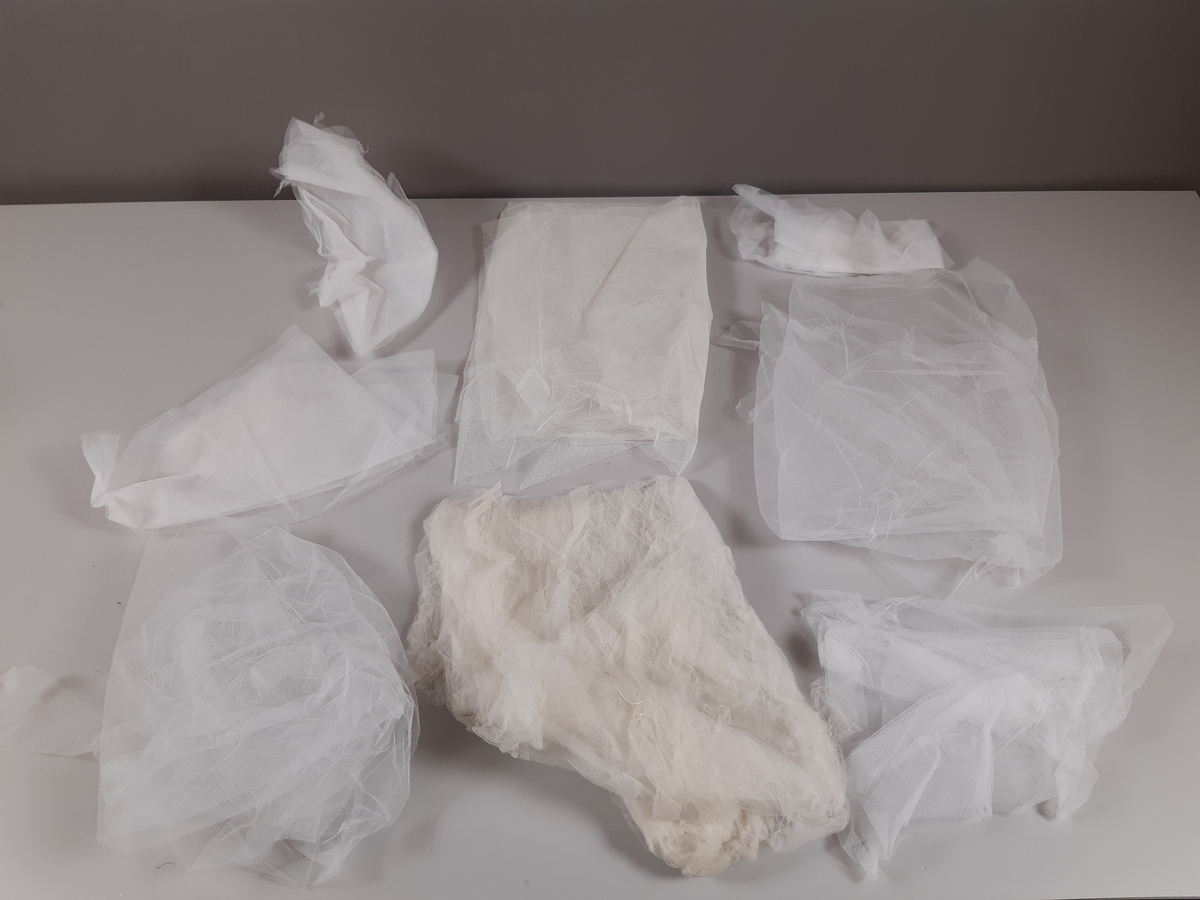 Tyll i ljusbrun, vitt och svart med fästade glaskristaller.
