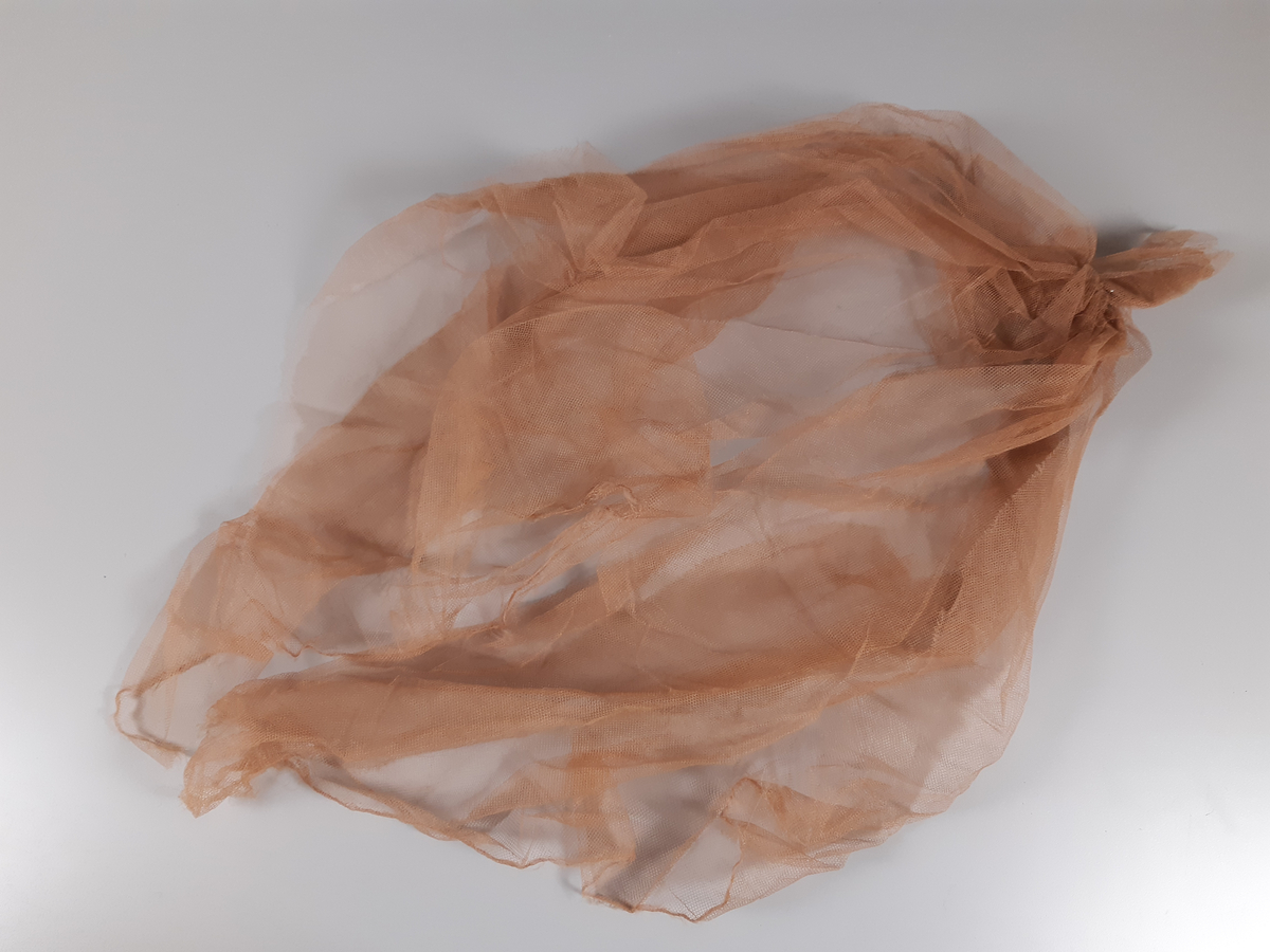 Tyll i ljusbrun, vitt och svart med fästade glaskristaller.
