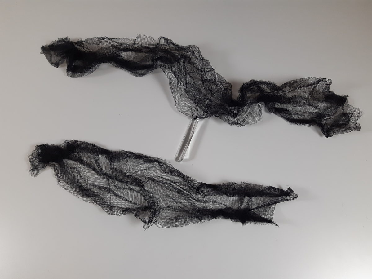 Tyll i ljusbrun, vitt och svart med fästade glaskristaller.
