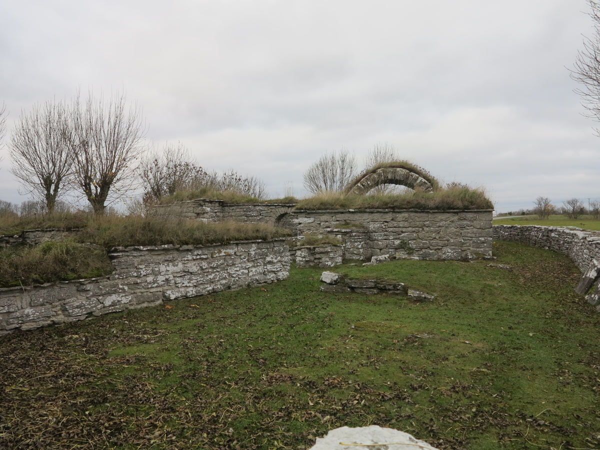 Lau kastal och prästgårdsruin.

Ruin av medeltida stenhus jämte mindre markområde. Anläggningen utgörs av två sammanbyggda hus av olika ålder. Det äldre är en mellanform mellan kastal och ett förrådshus. Bottenvåningen, som ensam är bevarad, delas genom en kraftig mellanvägg i två lika stora tunnvälvda rum. Ingången är belägen i markplanet och för in till en smal korridor, som fortsätter i en murtrappa i den breda främre muren. Huset har sålunda haft ytterligare minst en våning. Typen överensstämmer nära med medeltidshuset vid Kastelle i Vamlingbo.

Det yngre huset, som begagnar det äldres sydmur som gavel, visar bostadshusets karaktäristiska kännetecken. Ingången på ena långsidan för in till en förstuga, varifrån dörrar lett in till den äldre byggnaden, dels till en liten kammare innanför förstugan och dels till en vardagsstuga med en stor eldstad till höger om ingången.