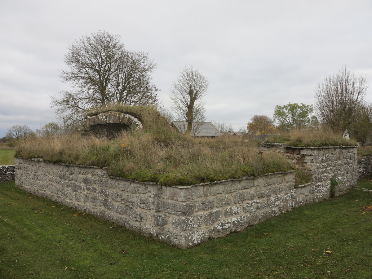 Lau kastal och prästgårdsruin.

Ruin av medeltida stenhus jämte mindre markområde. Anläggningen utgörs av två sammanbyggda hus av olika ålder. Det äldre är en mellanform mellan kastal och ett förrådshus. Bottenvåningen, som ensam är bevarad, delas genom en kraftig mellanvägg i två lika stora tunnvälvda rum. Ingången är belägen i markplanet och för in till en smal korridor, som fortsätter i en murtrappa i den breda främre muren. Huset har sålunda haft ytterligare minst en våning. Typen överensstämmer nära med medeltidshuset vid Kastelle i Vamlingbo.

Det yngre huset, som begagnar det äldres sydmur som gavel, visar bostadshusets karaktäristiska kännetecken. Ingången på ena långsidan för in till en förstuga, varifrån dörrar lett in till den äldre byggnaden, dels till en liten kammare innanför förstugan och dels till en vardagsstuga med en stor eldstad till höger om ingången.