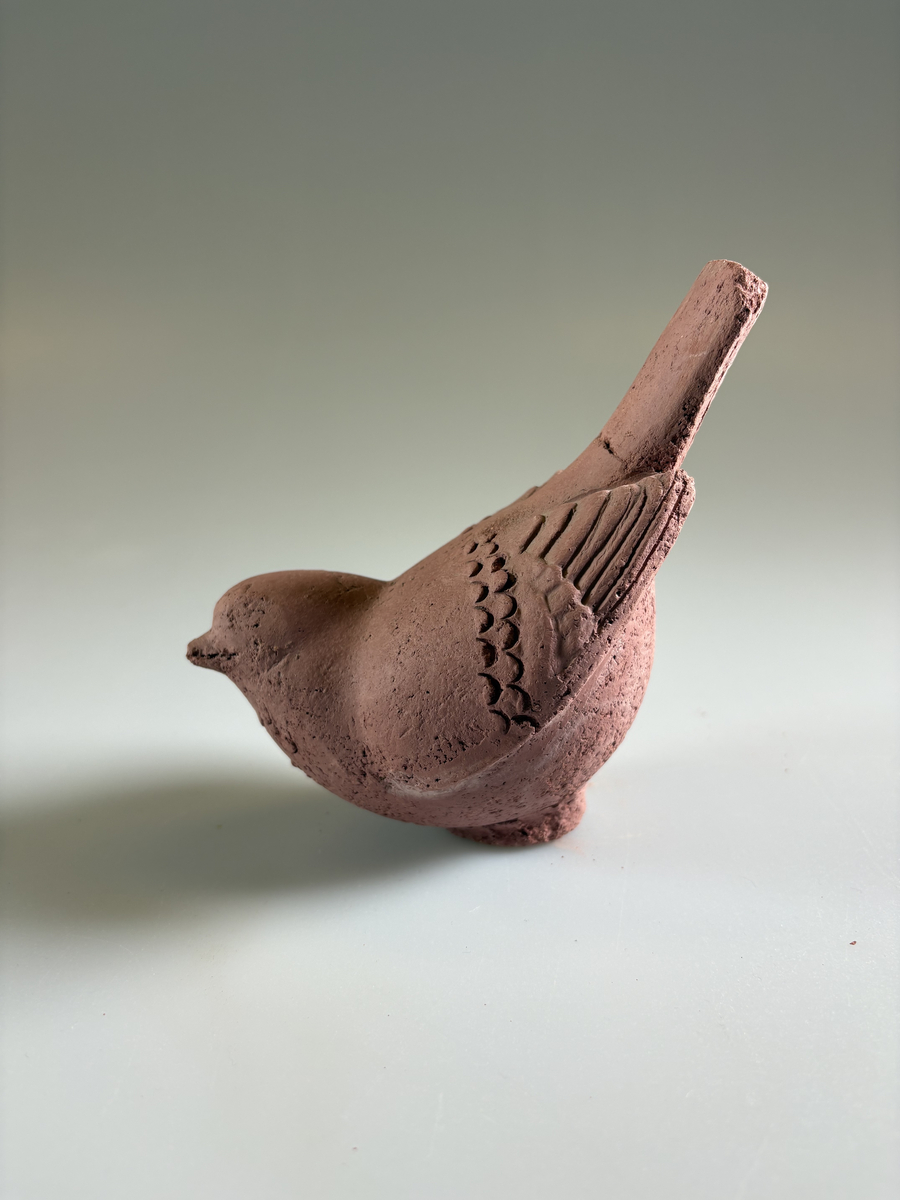 Skulptur av Tyra Lundgren, obränd lera. Föreställande fågel med stjärtfjädrarna uppåt. Stjärten limmad.