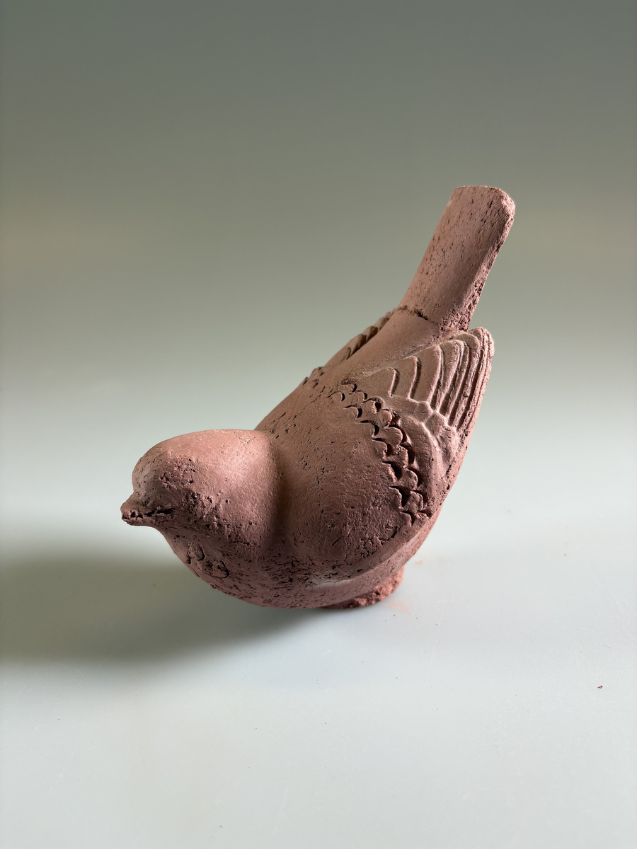 Skulptur av Tyra Lundgren, obränd lera. Föreställande fågel med stjärtfjädrarna uppåt. Stjärten limmad.