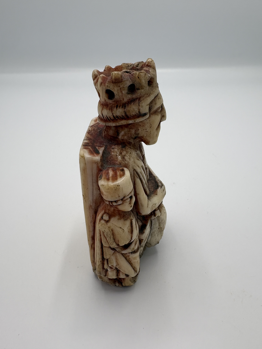 Schackkung av valrosstand med två smärre bilder på sidorna. Krona på huvudet, delvis rödmålad. På baksidan märkt med ett ankare, samt: "1606" och "* N S *". Personen till vänster om kungen är iklädd en lång dräkt och rund mössa, den högra mannen är är barhuvad och bär en knappförsedd dräkt med mantel över. Han håller också en spira eller kort stav i händerna. Pjäsen är genomborrad från kungen hjässa och rakt ner.

Det är osäkert om den röda färgen som man ser spår av är original eller senare ditmålad, men den måste ha påförts före år 1606. Det inristade ankaret kan tyda på att pjäsen vid 1600-talets början ägdes av en sjökapten eller sjöman, men vi saknar kunskap om vem som ursprungligen förde pjäsen till Gotland. Var den en del av ett komplett schackspel eller kom den till ön som ensam souvenir?

Pjäsen bör ha kommit i donatorns (läroverkslektor C J Bergman) ägo mellan åren 1846-1874. 1874 vittnar nämligen Bergmans kollega vid läroverket och blivande museiföreståndaren P A Säve om att den märkliga kungafiguren finns hos Bergman och att han lovat skänka den till det planerade museet. Fram till 1846 hade kungen haft en speciell användning: som handtag i en klocksträng i sessionssalen på Skomakargillets hus i hörnet Ryska gränd och Övre och Nedre Finngränd i Visby. Klocksträngen manövrerade en klocka som var upphängd i taket, varmed åldermannen äskade tystnad vid gillets sammankomster. Gillet höll sina möten i detta hus från år 1592-1846 (då gillet upplöstes), men inskriptionen med årtalet 1606 antyder att det inte kommit i Skomakargillets ägo förrän under 1600-talets första hälft.

Enligt Roosval och af Ugglas är pjäsen sannolikt tillverkad någon gång 1350-1370.