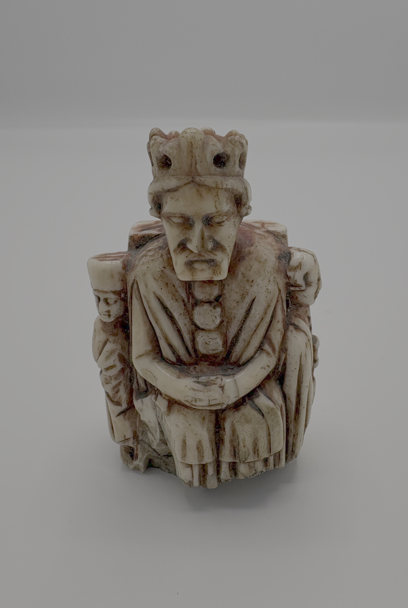 Schackkung av valrosstand med två smärre bilder på sidorna. Krona på huvudet, delvis rödmålad. På baksidan märkt med ett ankare, samt: "1606" och "* N S *". Personen till vänster om kungen är iklädd en lång dräkt och rund mössa, den högra mannen är är barhuvad och bär en knappförsedd dräkt med mantel över. Han håller också en spira eller kort stav i händerna. Pjäsen är genomborrad från kungen hjässa och rakt ner.

Det är osäkert om den röda färgen som man ser spår av är original eller senare ditmålad, men den måste ha påförts före år 1606. Det inristade ankaret kan tyda på att pjäsen vid 1600-talets början ägdes av en sjökapten eller sjöman, men vi saknar kunskap om vem som ursprungligen förde pjäsen till Gotland. Var den en del av ett komplett schackspel eller kom den till ön som ensam souvenir?

Pjäsen bör ha kommit i donatorns (läroverkslektor C J Bergman) ägo mellan åren 1846-1874. 1874 vittnar nämligen Bergmans kollega vid läroverket och blivande museiföreståndaren P A Säve om att den märkliga kungafiguren finns hos Bergman och att han lovat skänka den till det planerade museet. Fram till 1846 hade kungen haft en speciell användning: som handtag i en klocksträng i sessionssalen på Skomakargillets hus i hörnet Ryska gränd och Övre och Nedre Finngränd i Visby. Klocksträngen manövrerade en klocka som var upphängd i taket, varmed åldermannen äskade tystnad vid gillets sammankomster. Gillet höll sina möten i detta hus från år 1592-1846 (då gillet upplöstes), men inskriptionen med årtalet 1606 antyder att det inte kommit i Skomakargillets ägo förrän under 1600-talets första hälft.

Enligt Roosval och af Ugglas är pjäsen sannolikt tillverkad någon gång 1350-1370.