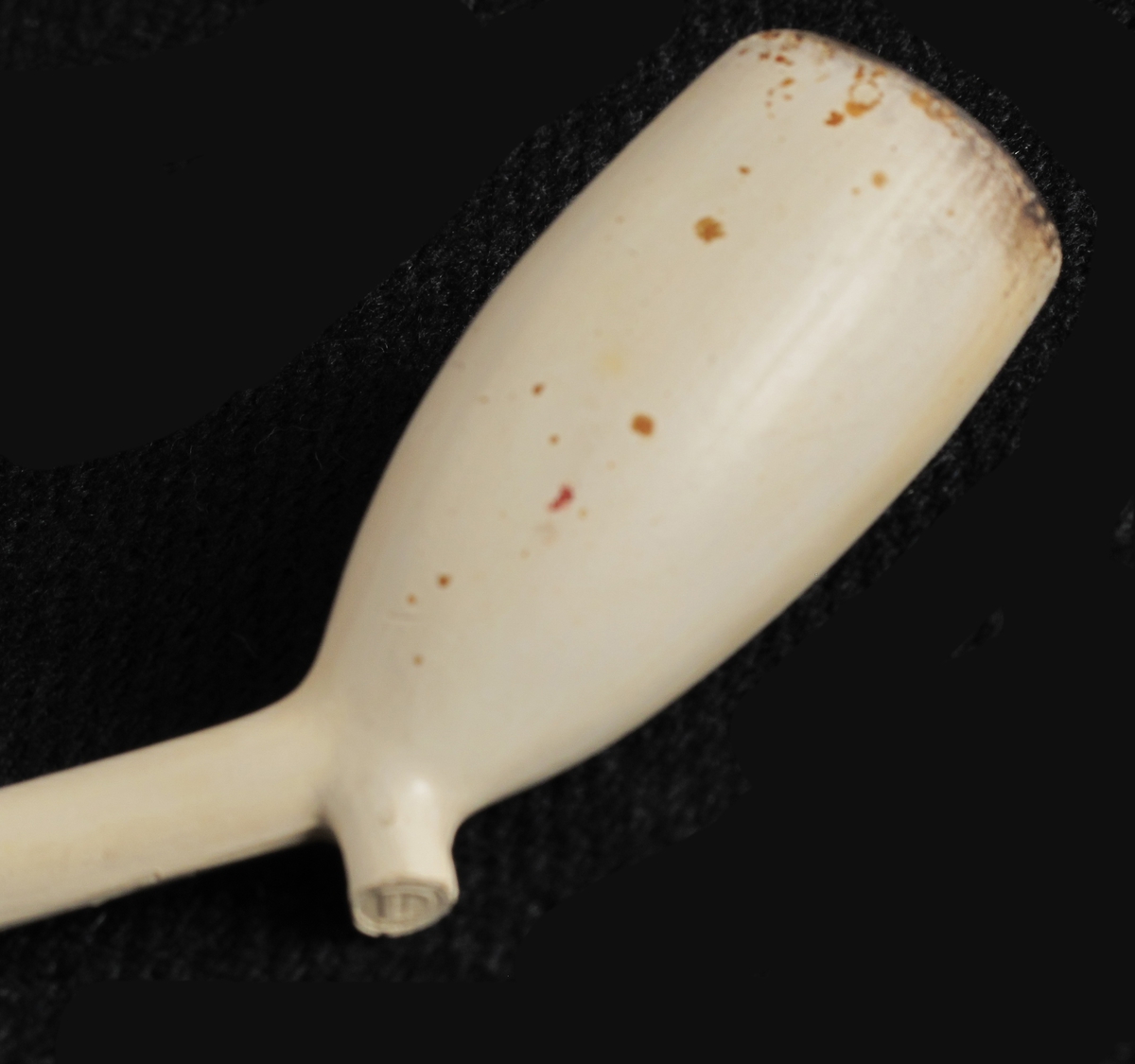 Krittpipe, hollandsk type, siste 3. del 1600 t.  Smalt hode, like bredt oppe som nede, med stor oval ståflate, tykt  kort skaft, avbrukket. Uten stempler.