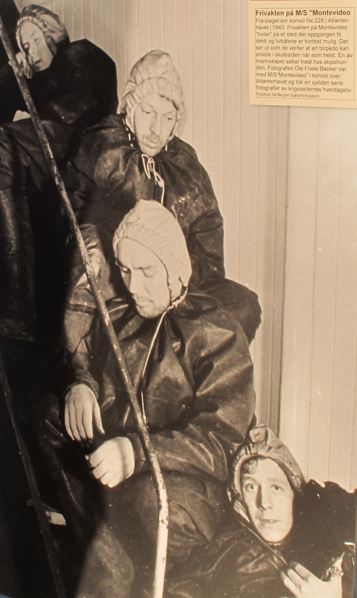 Gummidress, brukt av alliert marine og handelsflåte under krigen 1940 - 45. 
Sort dress med gul hette. Stor gummiddress med påsatte støvler, som har blyinnlegg for å holde drakten flytende loddrett. Lange ermer, vid halsåpning med snoretrekk og gul hette med innvendig hvit elastikk. Innv. bruksanvisning.  Stempel under sålen.