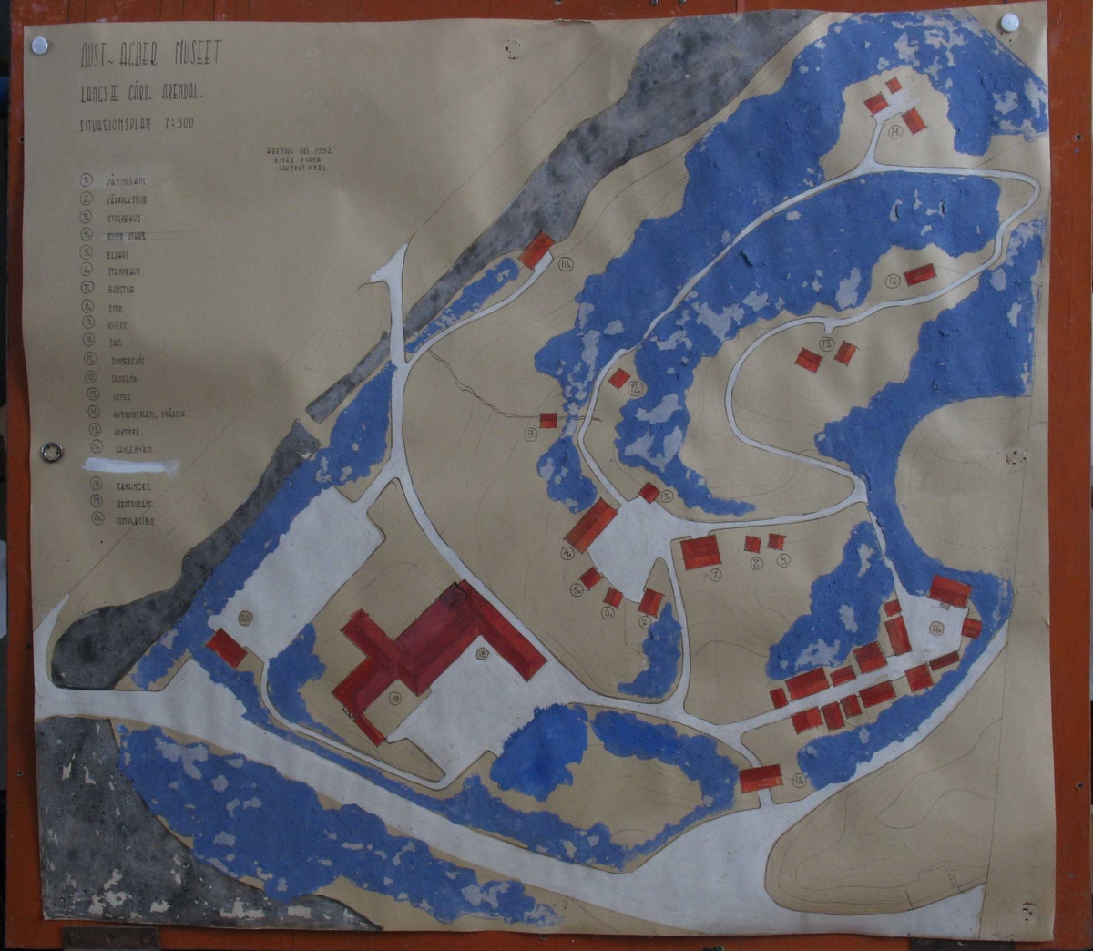 Plan og modell over Aust Agder Museet,  1952.   Furukasse  med   finerlokk,  I kassen en modell av Langsæterrenget,  med Barbuelva. Hovedbygningen fra 1858 er borte,  museumsbygget er større enn nå. Rundt i  terrenget spredte tun og bygate = Aust  Agder By og Folkemuseum (som omtalt bl. a.  i hefte 1934, Albert Uglands plan for museet).  