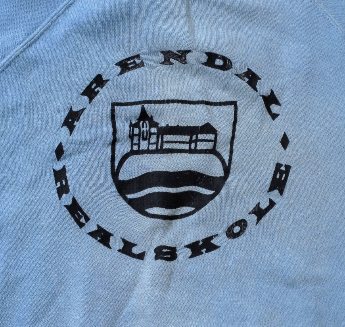 Enkel tegning av Tyholmen med skolen på toppan.