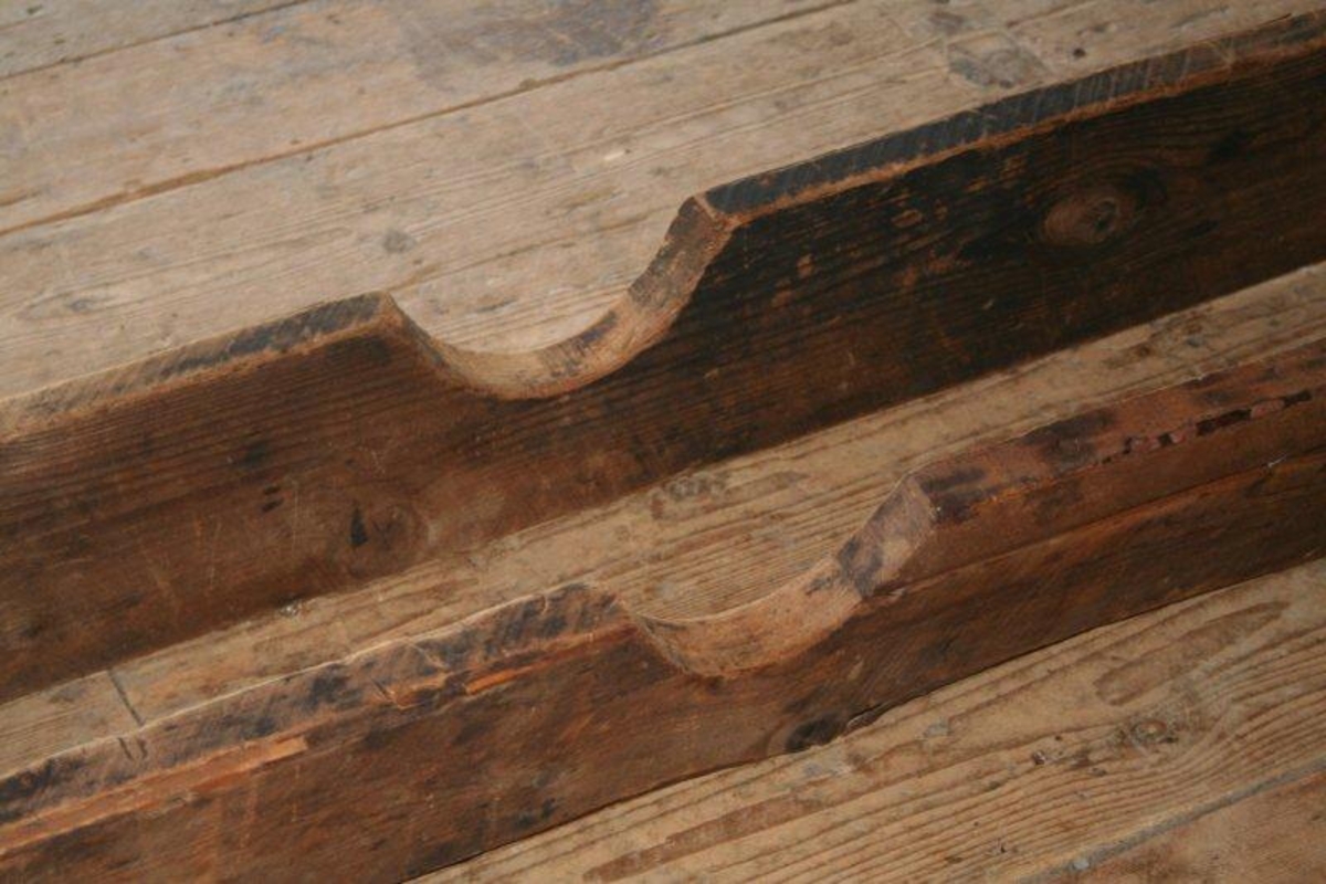 To treplanker parallelt ved siden av hverandre. I begge ender forbundet med et tverrstykke med strammeskrue. Midt på hver planke er en halvmåneformet utskjæring der hjulnavet ble lagt. På den ene planken er et mindre parti erstattet med nyere trevirke.