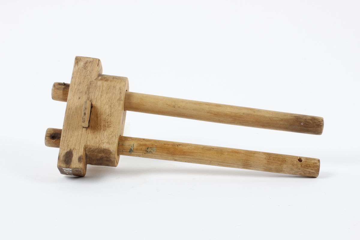 Et stykke med to hol. Gjennom hola to bevegelige, runde pinner med stift til å risse streker med. Trapesformet stykke gjennom hovedstykket mellom pinnene Tidl. reg.:"Strek-mott,  laget av skredder Kristian Braaten (far til O. Braaten) Sløydlærer Pastor Lars Hofgaard"