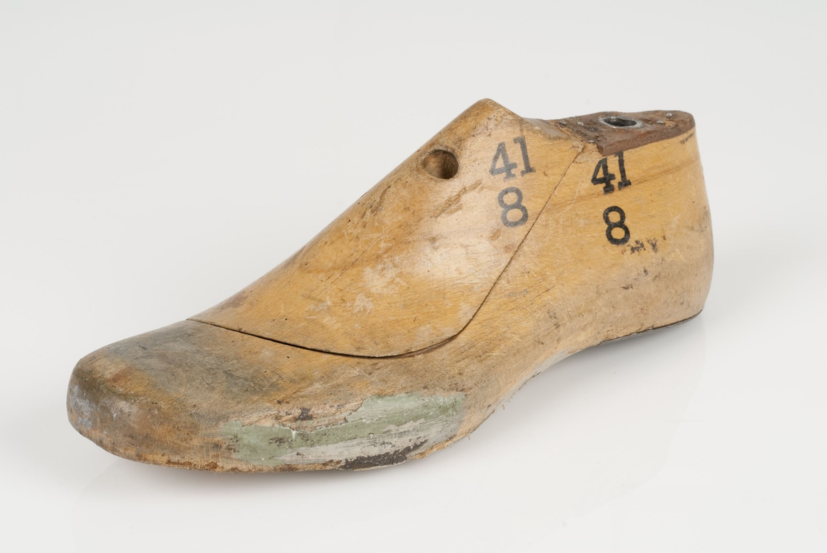 En tremodell i to deler; lest og opplest/overlest (kile).
Venstrefot i skostørrelse 41, og 8 cm i vidde.
Hælstykket i metall.