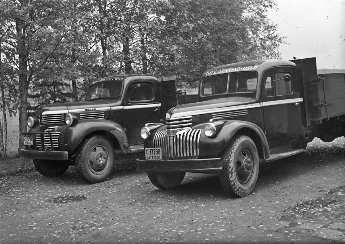 2 lastebiler. DODGE med reg.nr. C-17799 til venstre, Chevrolet med reg. nr. C-17798 til høyre. Det står skrevet IHLE – FENSTAD – OSLO på begge.
05.03.2013:
Begge disse bilene tilhørte min farfar, Rutebileier Karl Martinsen, Skogstad, 2170 FENSTAD.
Bilene gikk i godsrutetransport mellom Oslo og Fenstad og i melketransport rundt i Fenstad til Ihle Meieri. C 17799 , 1945 Dodge ble kjøpt rett etter krigen og var i bruk til utpå 60 tallet. Den ble solgt til Håvard Lunner på Frøyhov som gårdsbil. Denne bilen var en millitær modell som ble solgt som overskuddsmatriell.
C 17798, 1947 Chevrolet ble kjøpt hos Christiansen & Co i Oslo. Førerhus og lateplan ble bygget hos Sigurd Jensens karosserifabrikk på Styri i Eidsvoll.
Bilen var i bruk til på slutten av 60 tallet.
Skrevet av: Geir Martinsen
07.04.2014:
1947 Chevrolet med førerhus fra min farfar, Sigurd Jensen. Bilen tilhørte Karl Martinsen, Fenstad. Han drev godsruta Ihle-Fenstad -Kløfta-Vormsund. Registreringsmerket C-17798 var overtatt fra "Sølvbussen" som var lagd hos Sigurd Jensen-karosserifabrikk. (Etablert i 1936). Kilde: "Håndverk på hjul-Karosserifabrikker og karosseribygging i Norge". Asbjørn Rolseth.
Skrevet av: Kirsti Bokn