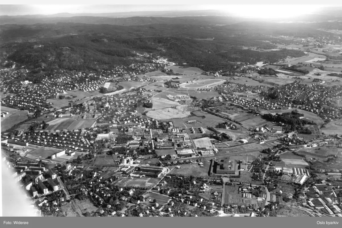 Panoramabilde. Sinsen til venstre, Aker sykehus lenger opp, Bjerke travbane bak, Risløkka og Økern til høyre, Marka og jordbruk i Groruddalen bak. (Flyfoto)