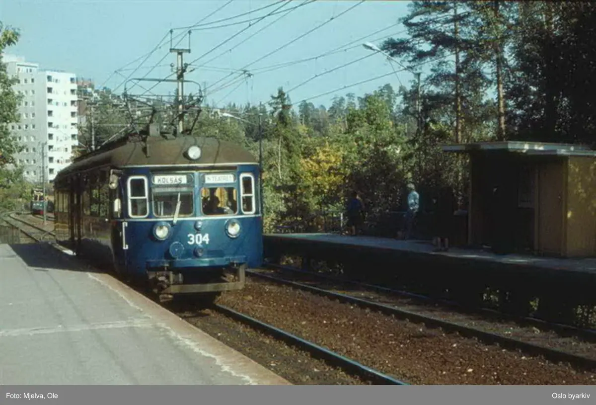 Oslo Sporveier. Motorvogn 304 type C1 på Kolsåsbanen ankommer Ullernåsen stasjon. Bua på inngående plattform var krypinn for pendelkonduktøren.